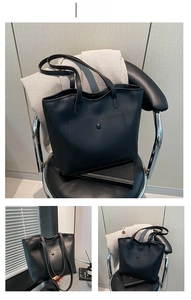 Close-up of black matte leather tote bag featuring a front pocket with round snap button