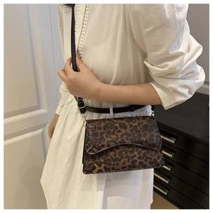 Borsa a tracolla con stampa leopardata indossata con un abito bianco elegante