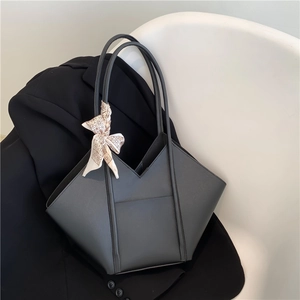 Minimalist black geometric tote bag with decorative silk scarf on handle, modern office style