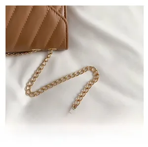 Nahaufnahme der braun gesteppten Ledertasche mit hellgoldener Metallkette im Detail