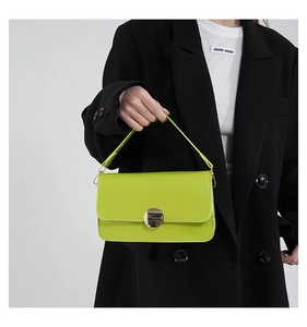 Détail du sac à bandoulière vert vif avec une grande boucle ronde en métal doré