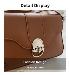 Close-up of brown leather baguette bag showing silver buckle and fine stitching detail