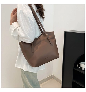 Detailed macro view of dark brown tote bag material with fine texture and metal buckle