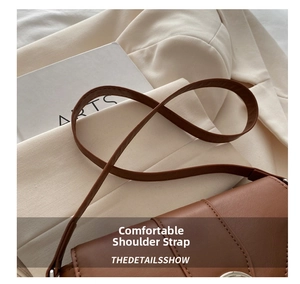 Close-up of brown leather bag shoulder strap with high-quality stitching detail