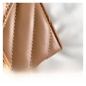 Makroaufnahme von khakifarbenem Lederdetail mit eleganter V-Steppung und feiner Nahtverarbeitung