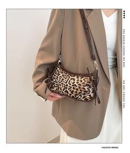 Detail der sichelförmigen Tasche mit Leopardenmuster, Lederbesatz und Seitenschleifen