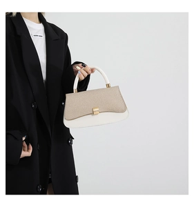 Detail of elegant cream leather and woven texture handbag with gold metal clasp