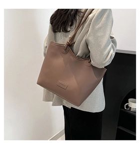 Detailed back view of a brown minimalist tote bag with knot strap detail and logo