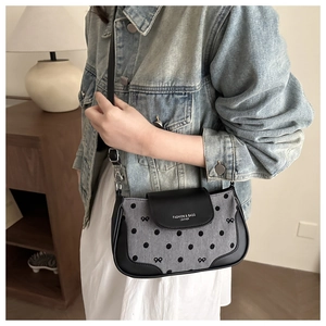 Détail du sac à bandoulière en denim gris avec pois noirs et sangle réglable