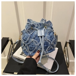 Dettaglio borsa a secchiello in denim blu chiaro con trama trapuntata e coulisse