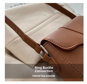 Macro shot of silver metal ring hardware and precision stitching on tan leather bag