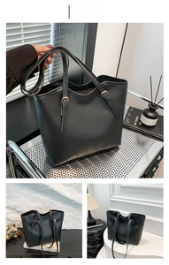 Detail of matte black tote bag showing durable shoulder strap and gold adjustment buckle