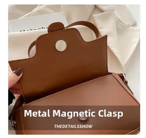Macro view of brown leather flap bag featuring silver magnetic buckle closure details