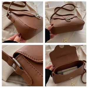 Macro details of brown PU leather baguette bag featuring silver buckles and interior storage