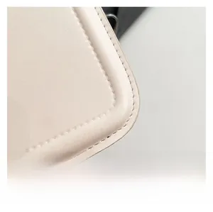 Detail showing high-quality beige leather stitching and smooth rounded edge of square bag