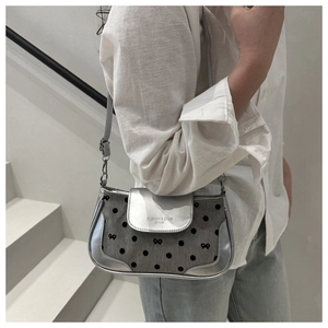Sac bandoulière argenté tendance avec motifs à pois et nœud porté à l'épaule