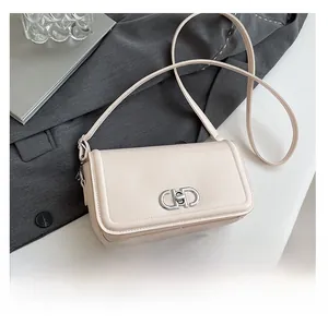 Close-up of cream PU leather crossbody bag featuring silver CD metal clasp and strap