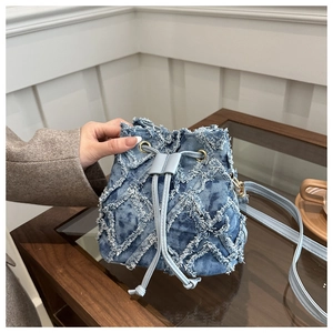 Dettaglio borsa a secchiello in denim con motivo a rombi usurati e finiture dorate