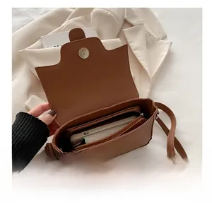 Interior capacity show of brown leather crossbody bag with smartphone and wallet
