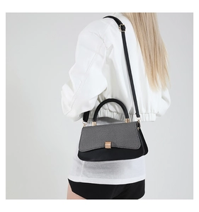 Detail of grey woven texture and black leather patchwork on chic women crossbody bag