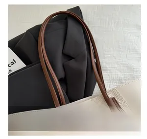Detailed close-up of ivory crocodile embossed tote bag with smooth brown leather handles