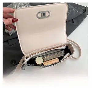 Interior view showing the capacity and compartments of the minimalist beige crossbody bag