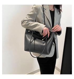Detail of minimalist black PU leather tote bag featuring a 'FASHION' letter patch
