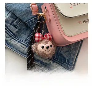 Detail of plush bear charm with gingham bow on a pink contrast shoulder bag