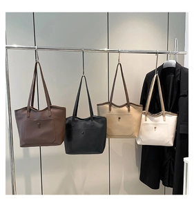 Row of minimalist tote bags in dark brown, black, and beige with front magnetic pockets