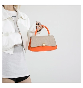 Detail of color-block structured handbag with orange leather and beige woven fabric