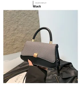 Detail of black leather and grey fabric saddle bag with a golden metal snap button