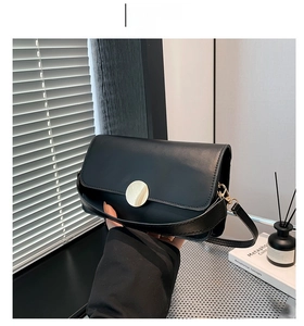 Détail du sac à bandoulière noir minimaliste en cuir PU avec boucle en métal dorée