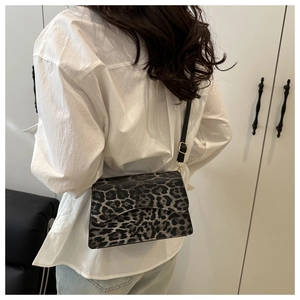 Dettaglio della borsa a spalla leopardata con patta magnetica e tracolla in pelle nera