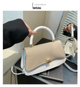 Detail of white leather handbag with beige woven texture flap and golden hardware