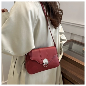 Borsa baguette rossa con fibbia ad anello argento indossata come borsa a tracolla chic