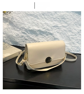Détail du sac bandoulière crème kaki avec boucle dorée ronde et fine bandoulière