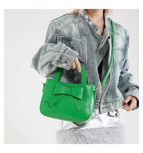 Dettaglio della borsa verde lime con fiocco decorativo e tracolla rimovibile