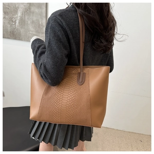 Close-up of large tote bag with brown faux snake skin texture and smooth leather panels