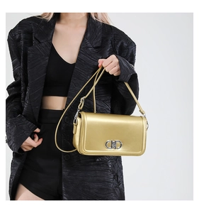 Detail of gold faux leather crossbody bag with silver buckle and versatile straps