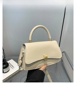 Detail view of khaki leather bag with elegant gold square metal clasp and top handle