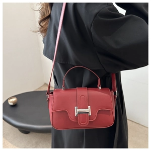 Detail of red square handbag with silver metallic buckle and adjustable shoulder strap