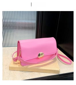 Vue détaillée du sac bandoulière rose en cuir mat avec boucle ronde en métal doré