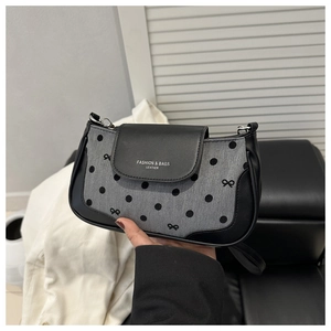 Détail du sac sous l'aisselle à pois avec texture en cuir et motifs de nœuds