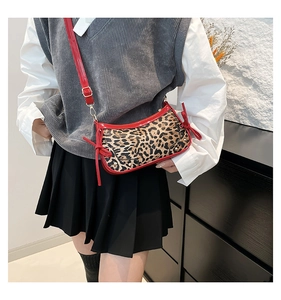 Detail of leopard print shoulder bag featuring red patent leather trim and a side bow knot