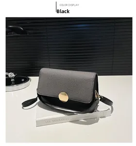 Détail du sac bandoulière en cuir noir avec rabat en tweed et fermoir doré sur un livre
