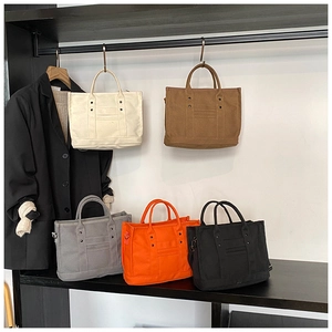 Detail shot of multi-color canvas tote bags with metal studs and D-ring attachments