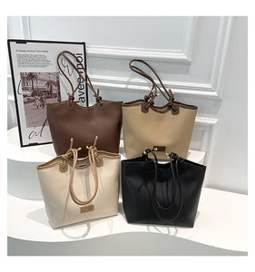 Close-up of four minimalist large tote bags in coffee, khaki, cream, and black colors