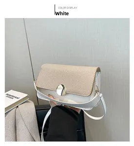 Détail du sac bandoulière en similicuir blanc et tissu tissé beige avec boucle dorée