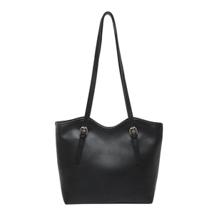 Minimalist black leather tote bag with unique wavy top edge and gold buckle straps