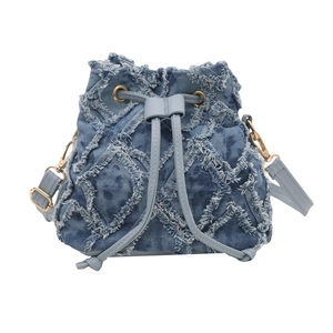 Borsa a secchiello in denim blu con motivo trapuntato sfilacciato e tracolla in pelle regolabile